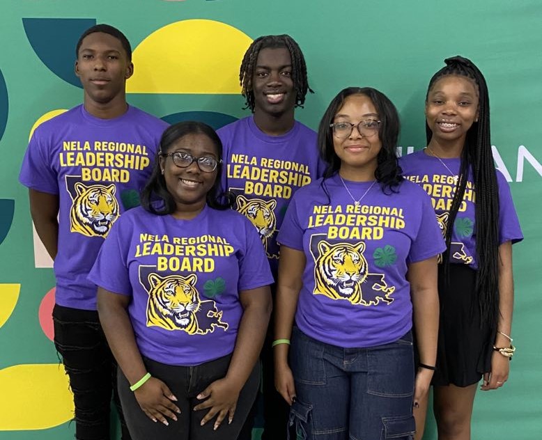 Five teenagers wearing LSU T-shirts posing for a photo.